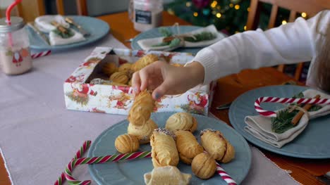 Child's-hand-reaching-out-to-take-christmas-cookies