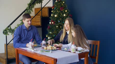 Familie-Essen-Weihnachtsplätzchen-am-festlich-gedeckten-Tisch