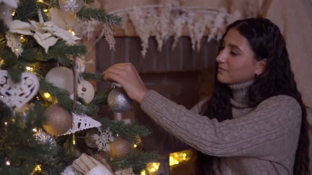 Eine-Mädchen-schmückt-einen-Weihnachtsbaum-mit-einem-schönen-Ball-mit-einer-guten-Stimmung.