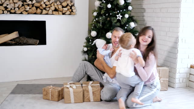 Family-having-fun-near-Christmas-tree-and-gifts