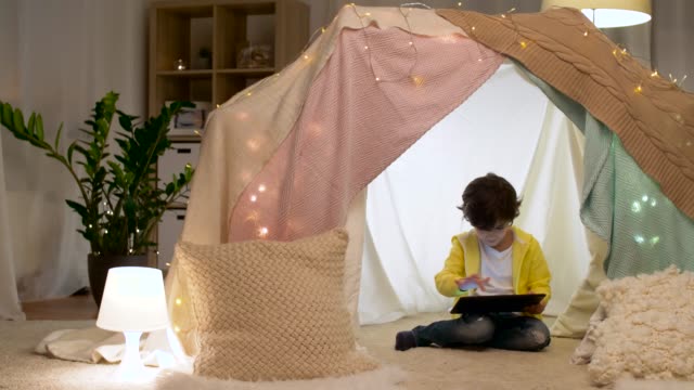 little-boy-with-tablet-pc-in-kids-tent-at-homea