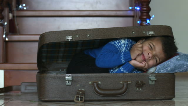 Jungen-schlafen-in-Koffer.