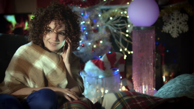4k-Christmas-and-New-Year-Holiday-Woman-Talking-on-Phone-at-Fireplace