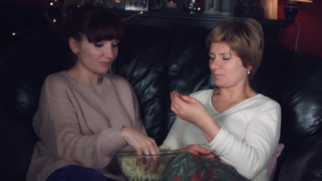 4k-Authentic-Shot-of-a-Girl-with-her-Mum-Talking-and-Eating-Popcorn