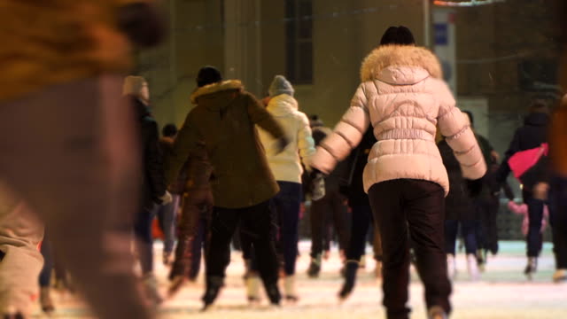 Concept-Friendship-and-Love.-Crowd-at-Night-City-Skating-Rink.-Falling-Snow