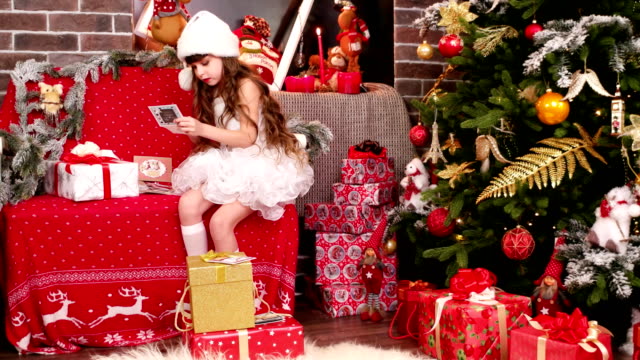 little-girl-lays-out-the-name-cards-on-Christmas-gifts