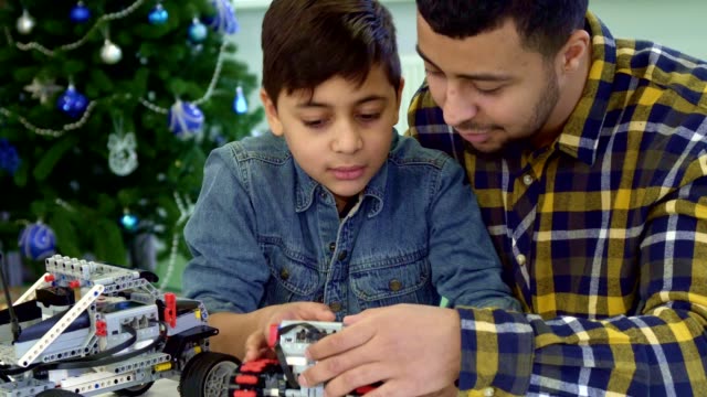 Father-and-son-examine-toy-tracked-ATV