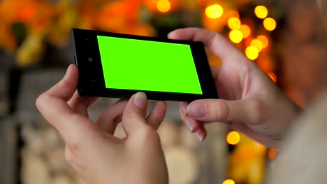 Mujer-buscando-a-smartphone-con-pantalla-verde