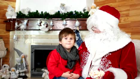 niño-diciendo-santa-sus-deseos-de-Navidad,-sala-con-chimenea,-muchacho-visita-residencia-de-santa-claus