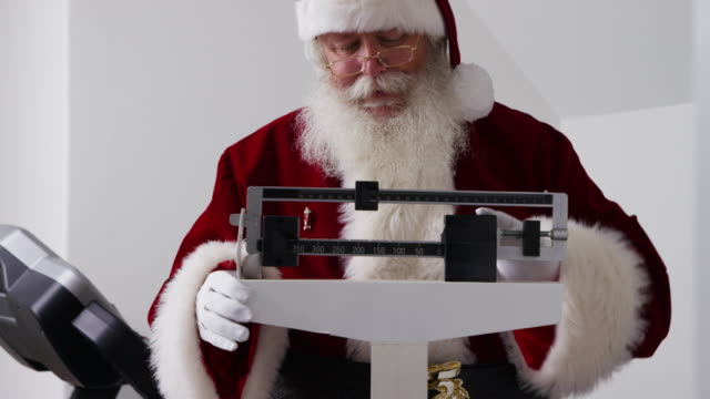 Santa-Claus-befasst-sich-mit-Gewicht-auf-der-Waage