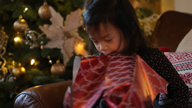 Young-girl-opening-gift-at-Christmas