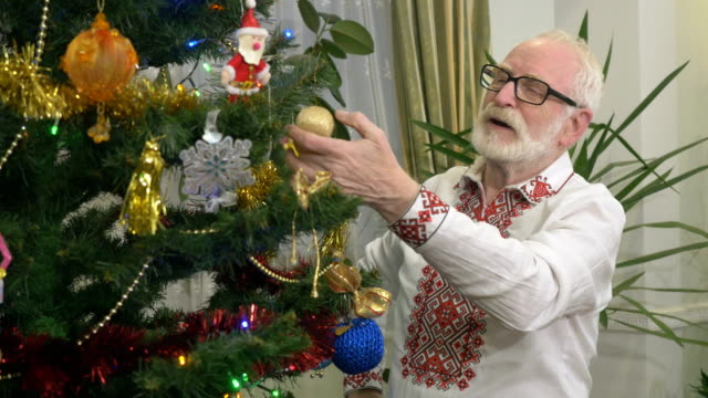 Hombre-agradable-se-ríe-cerca-del-árbol-de-Navidad