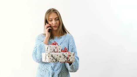 Young-girl-makes-a-photo-of-festive-presents-at-white-background