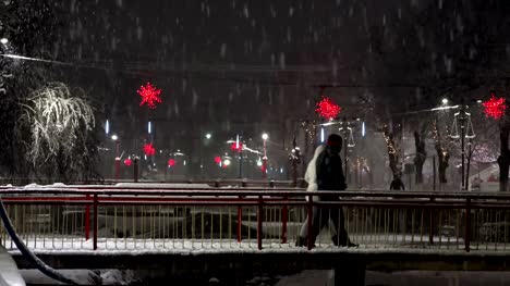 Urban-christmass-scene-of-people-walking-over-bridge-at-night-snow-blizzard