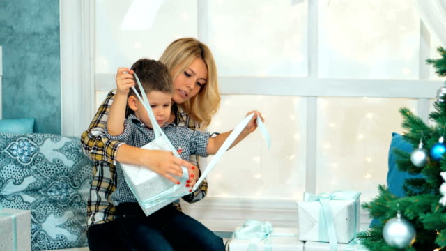 Glücklicher-kleine-Junge-öffnen-Weihnachts-Geschenk-Box-mit-Mama
