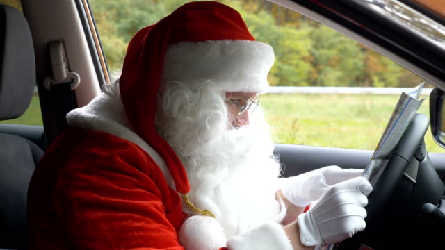Santa-Claus-lost-his-way-and-is-looking-at-the-map-in-car-50-fps