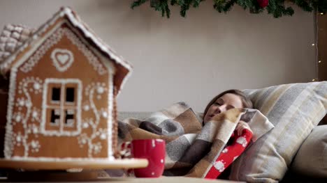tumbado-en-el-sofá-bajo-una-manta.-concepto-de-salud-y-enfermedad---de-mujer-enferma-con-taza-de-té.-Mañana-de-Navidad.