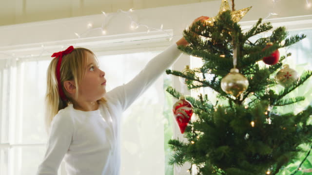 Junges-Mädchen-dekorieren-Weihnachtsbaum