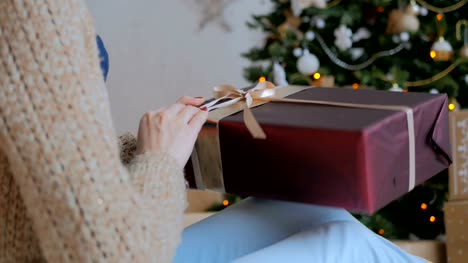 Woman-wraps-ribbon-on-christmas-gift-box