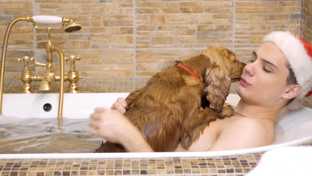 Junger-Mann-mit-seinem-Hund-nimmt-ein-heißes-Bad