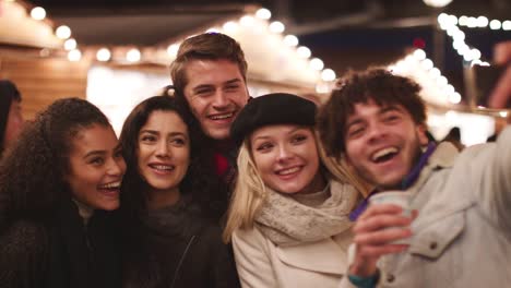 Junge-Freunde-posieren-für-Selfie-auf-Weihnachtsmarkt