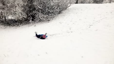 Young-girl-falling-off-a-snowy-sledge