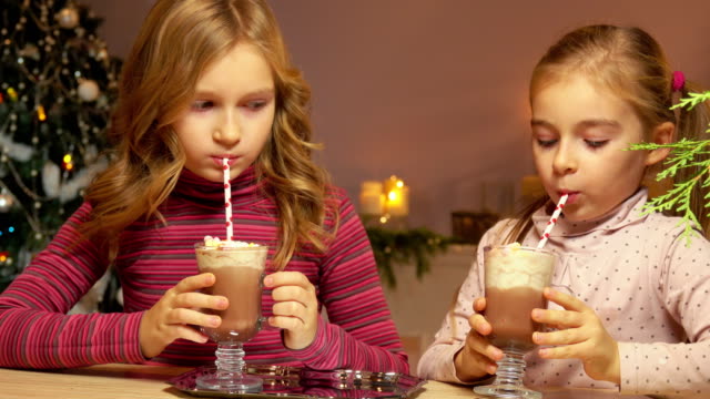 Mädchen-trinken-heiße-Schokolade-mit-einem-Strohhalm