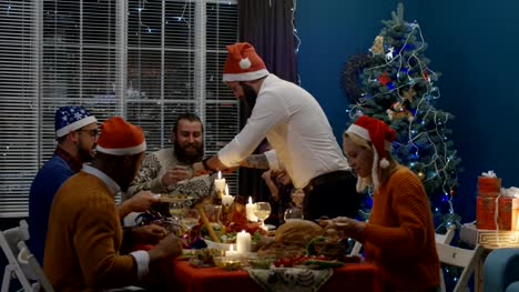 Laughing-friends-having-roasted-turkey-at-Christmas-dinner