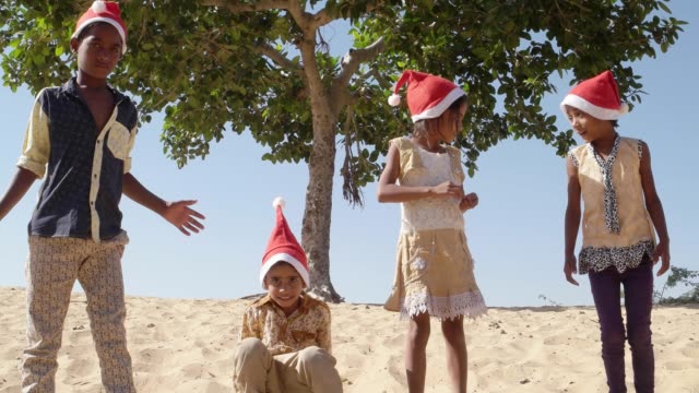 Niños-celebrando-la-Navidad-jugando-y-saltando-en-un-desierto