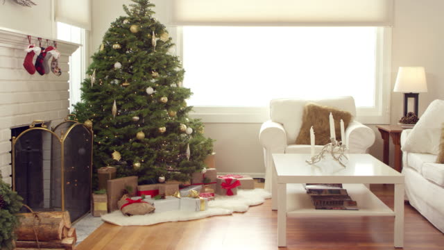 Un-árbol-de-Navidad-decorado-con-regalos-debajo-se-sienta-en-una-sala-de-estar