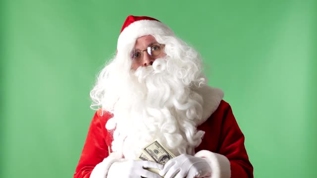 Satisfied-Santa-Claus-throwing-bills-out-of-a-bundle-money-rain,-concept,-green-chromakey-in-the-background