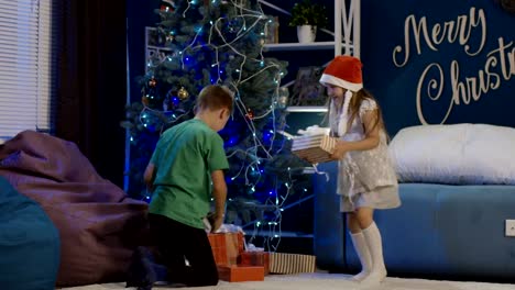 Happy-kids-unwrapping-Christmas-gifts-at-home