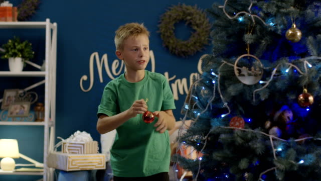 Junge-dekorieren-Weihnachtsbaum-zu-Hause
