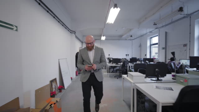 Man-entering-office-and-using-cell-phone