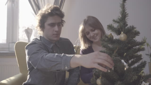 Young-couple-decorating-Christmas-tree