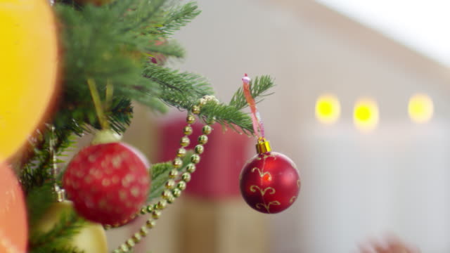 Chico-rizado-y-madre-decorar-árbol-de-Navidad