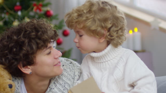 Entzückende-junge-Mutter-zu-küssen,-am-Weihnachtstag