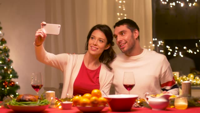 couple-taking-selfie-at-home-christmas-dinner