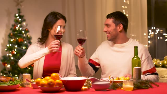 glückliches-Paar-trinken-Rotwein-am-Weihnachtsessen