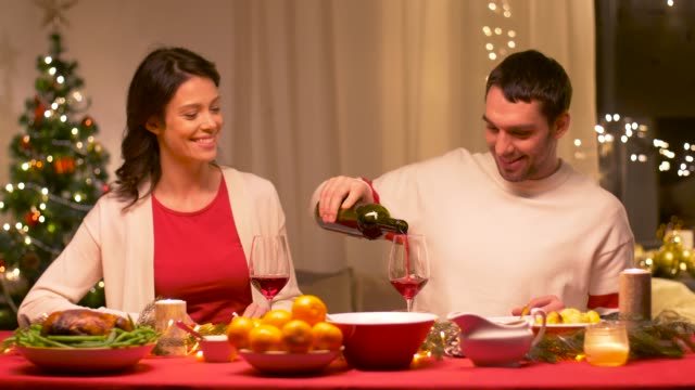 happy-couple-drinking-red-wine-at-christmas-dinner