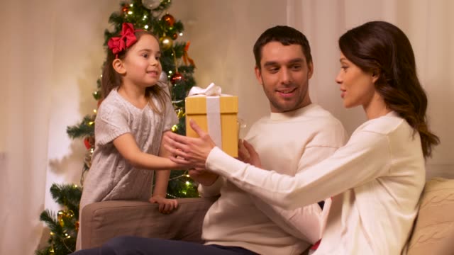 glückliche-Familie-mit-Weihnachtsgeschenk-zu-Hause