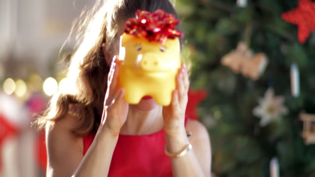 glücklich-stilvolle-Frau-mit-gelben-Sparschwein-Weihnachtsbaum