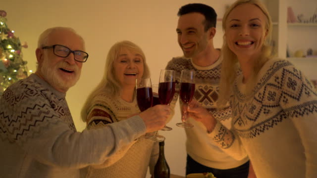 La-familia-feliz-bebiendo-vino-cerca-del-árbol-de-Navidad