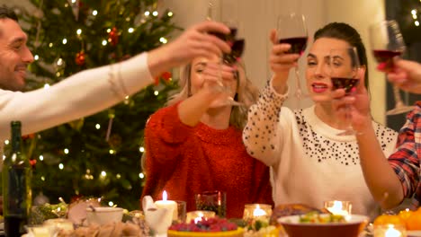 amigos-felices-bebiendo-vino-tinto-en-Navidad