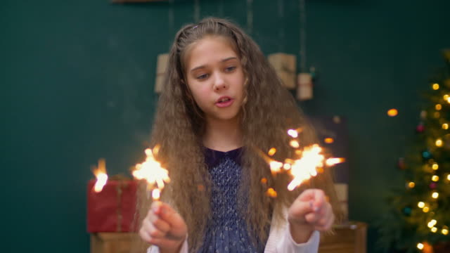 Cheerful-little-girl-playing-with-sparklers-at-xmas