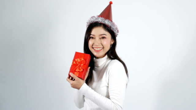 mujer-joven-feliz-con-sombrero-y-sosteniendo-una-caja-de-regalo-de-Navidad-Roja-sobre-un-fondo-blanco