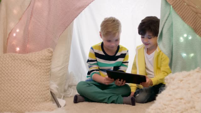 little-boys-with-tablet-pc-in-kids-tent-at-home