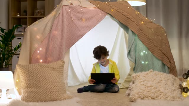 little-boy-with-tablet-pc-in-kids-tent-at-homea