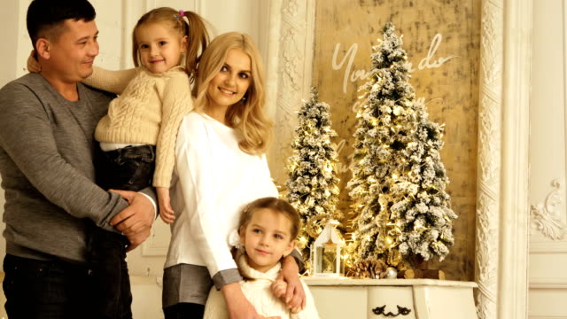 Portrait-of-happy-parents-with-two-daughters-posing.-Christmas-photo-session