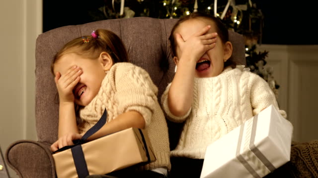 Girls-play-hiding-game-closing-their-faces-with-hands.-Christmas-kids,child,-portrait